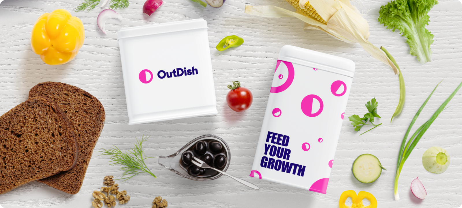 OutDish packaging mockups styled among bread, produce, and olives, with a Feed Your Growth tagline